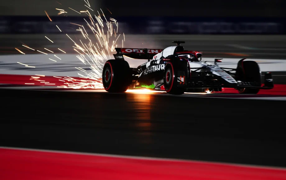 Sparks fly behind Liam Lawson driving the Scuderia AlphaTauri AT04